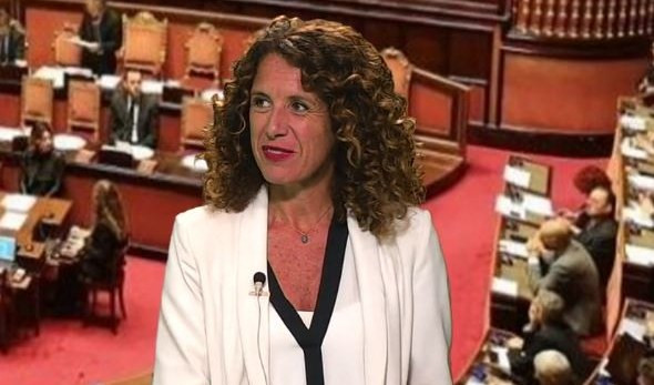 Una donna vestita di bianco con sullo sfondo il Parlamento