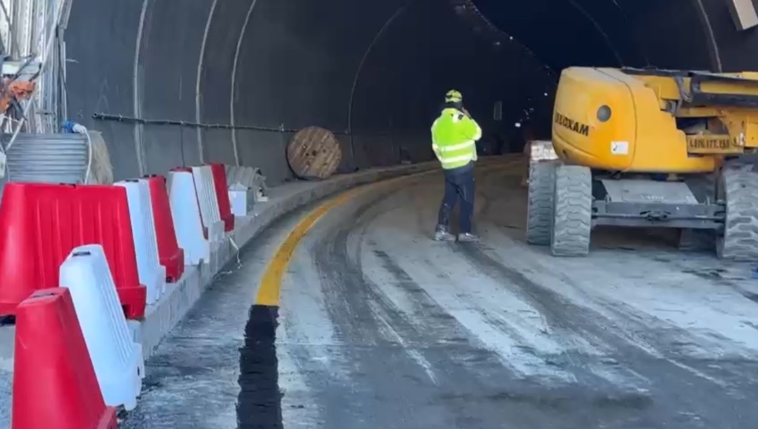 Una strada, un operaio e una ruspa