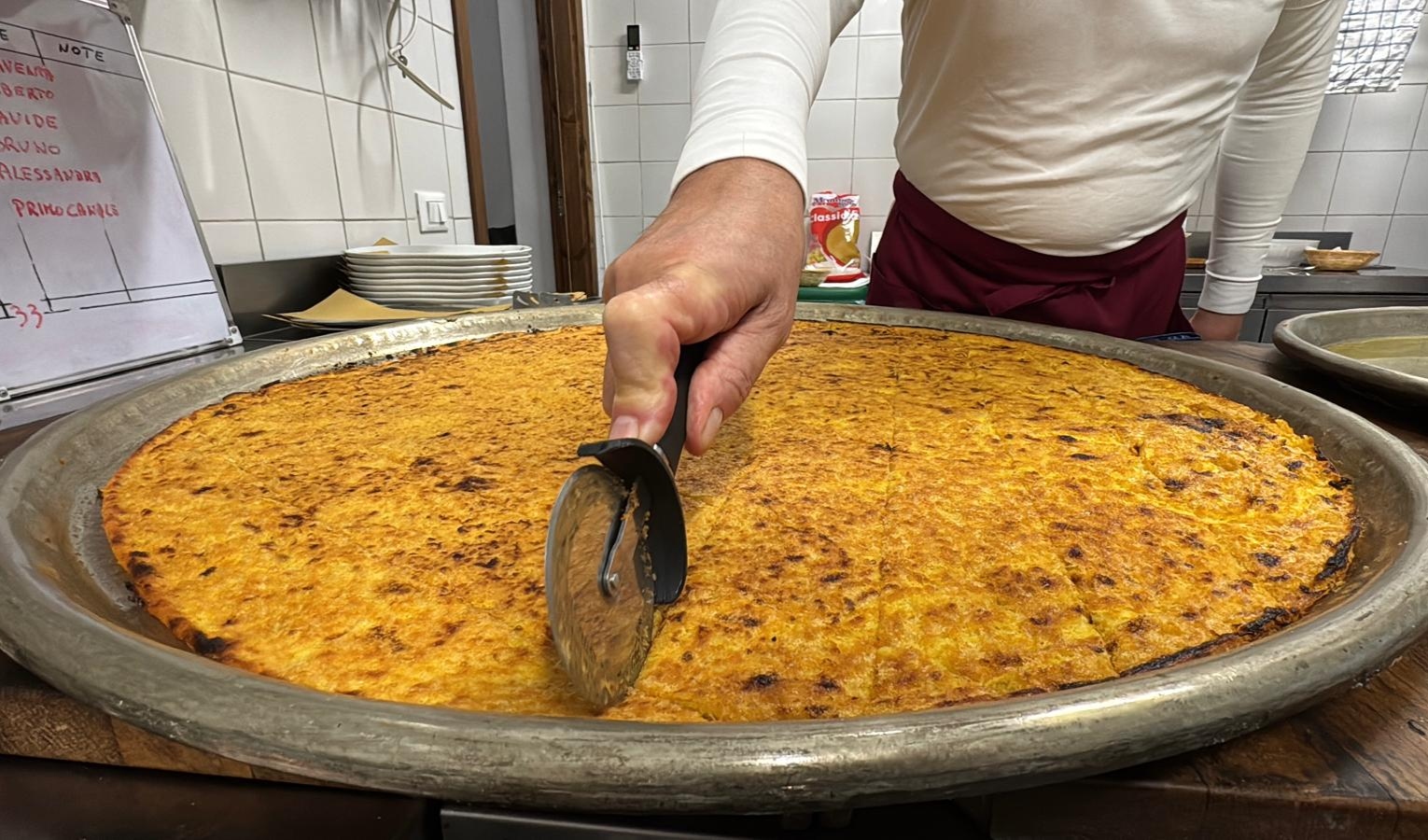 Una teglia di rame con all'interno una pietanza gialla