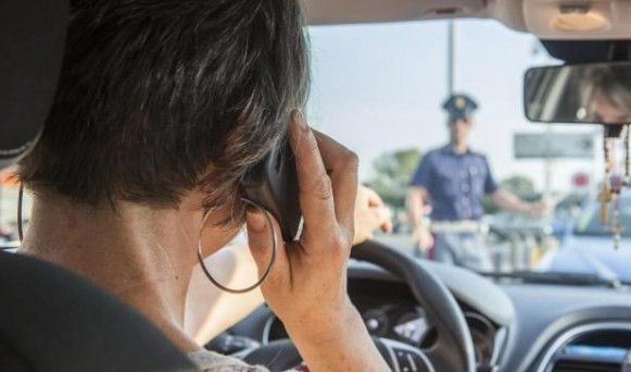 Una donna parla al cellulare in auto