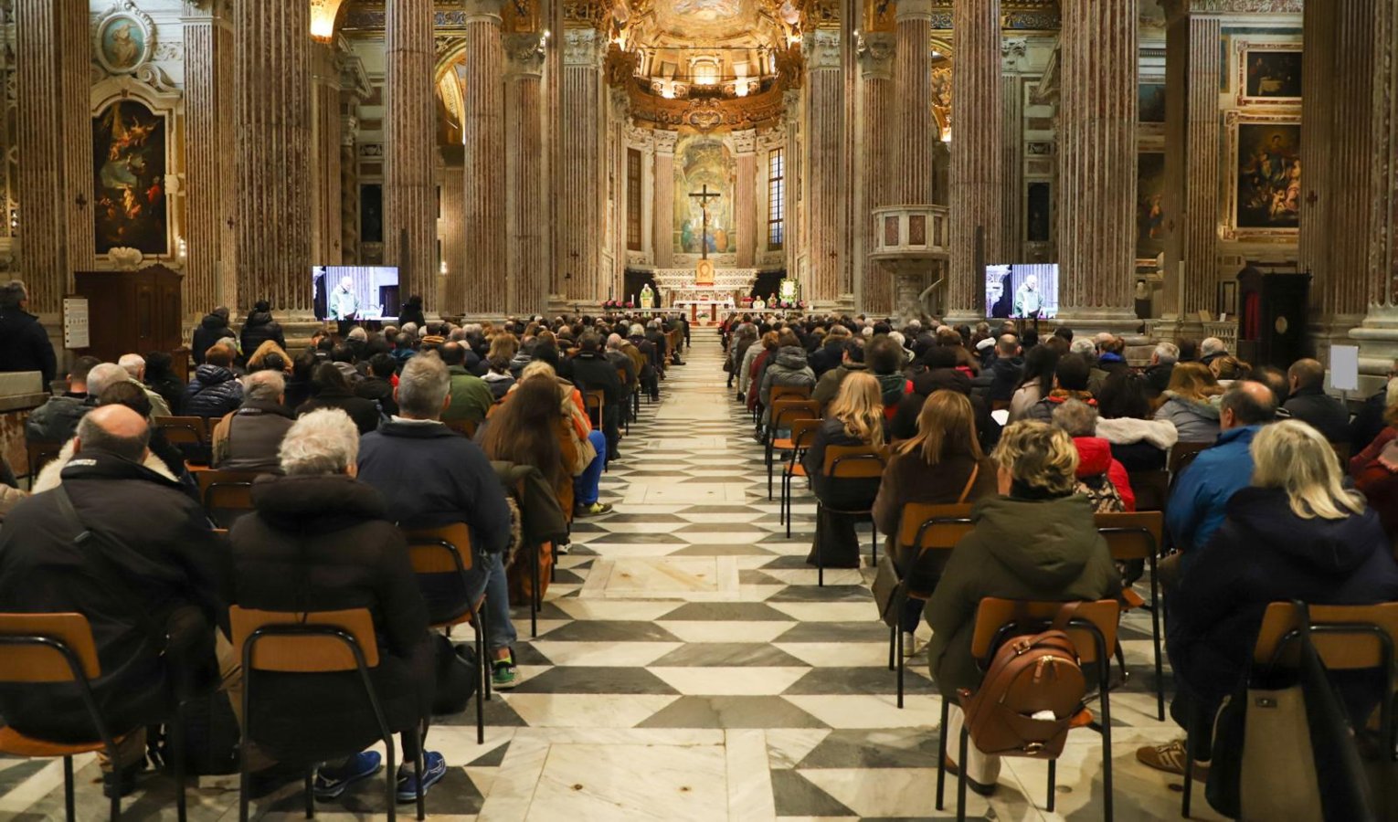 Persone sedute in una chiesa che assistono a una messa 