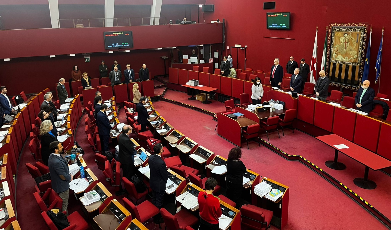 Persone in piedi in aula rossa a Genova