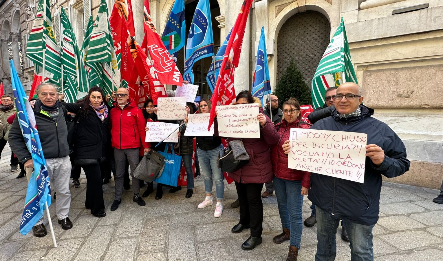 Persone in piedi con cartelli e bandiere