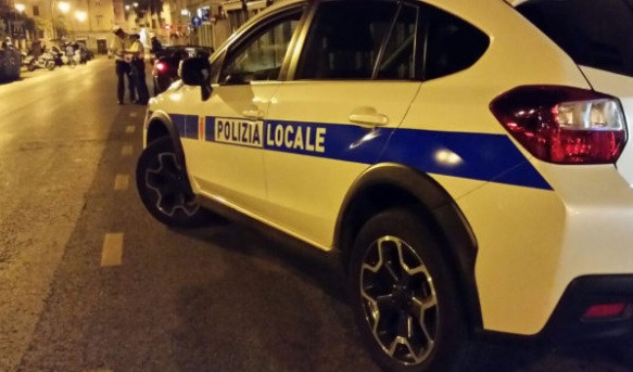 Una auto bianca con una striscia blu e la scritta polizia locale