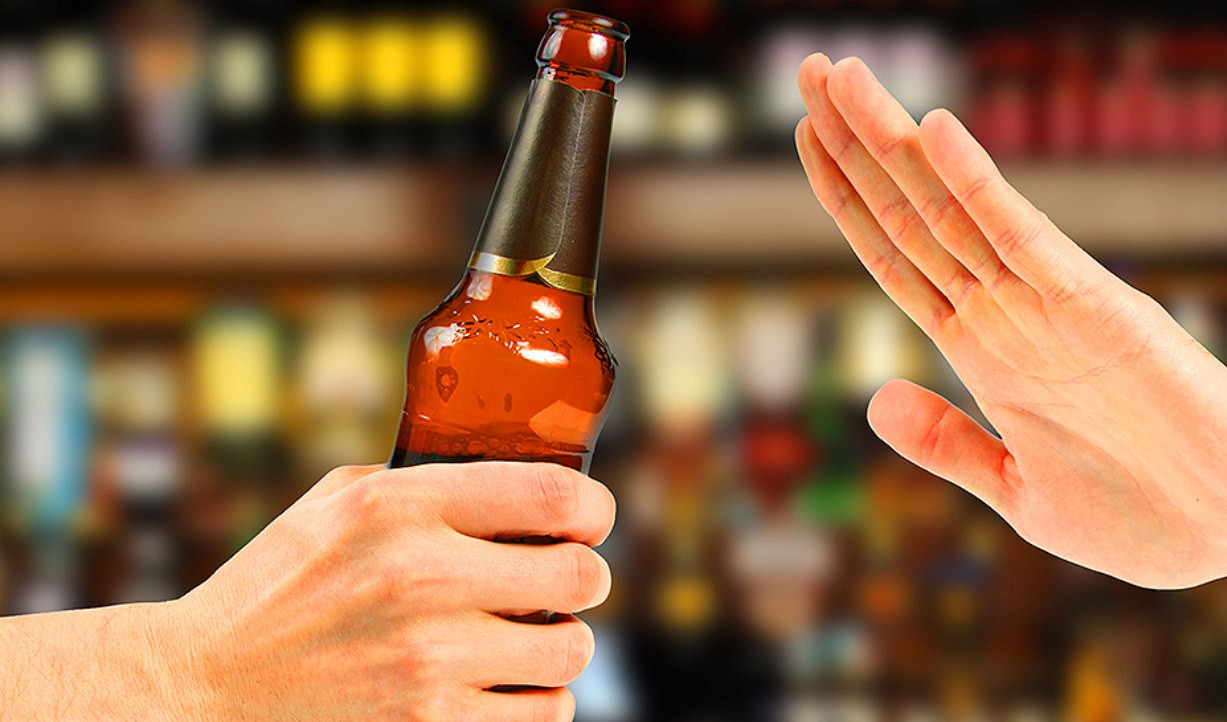 una bottiglia di alcol e una mano