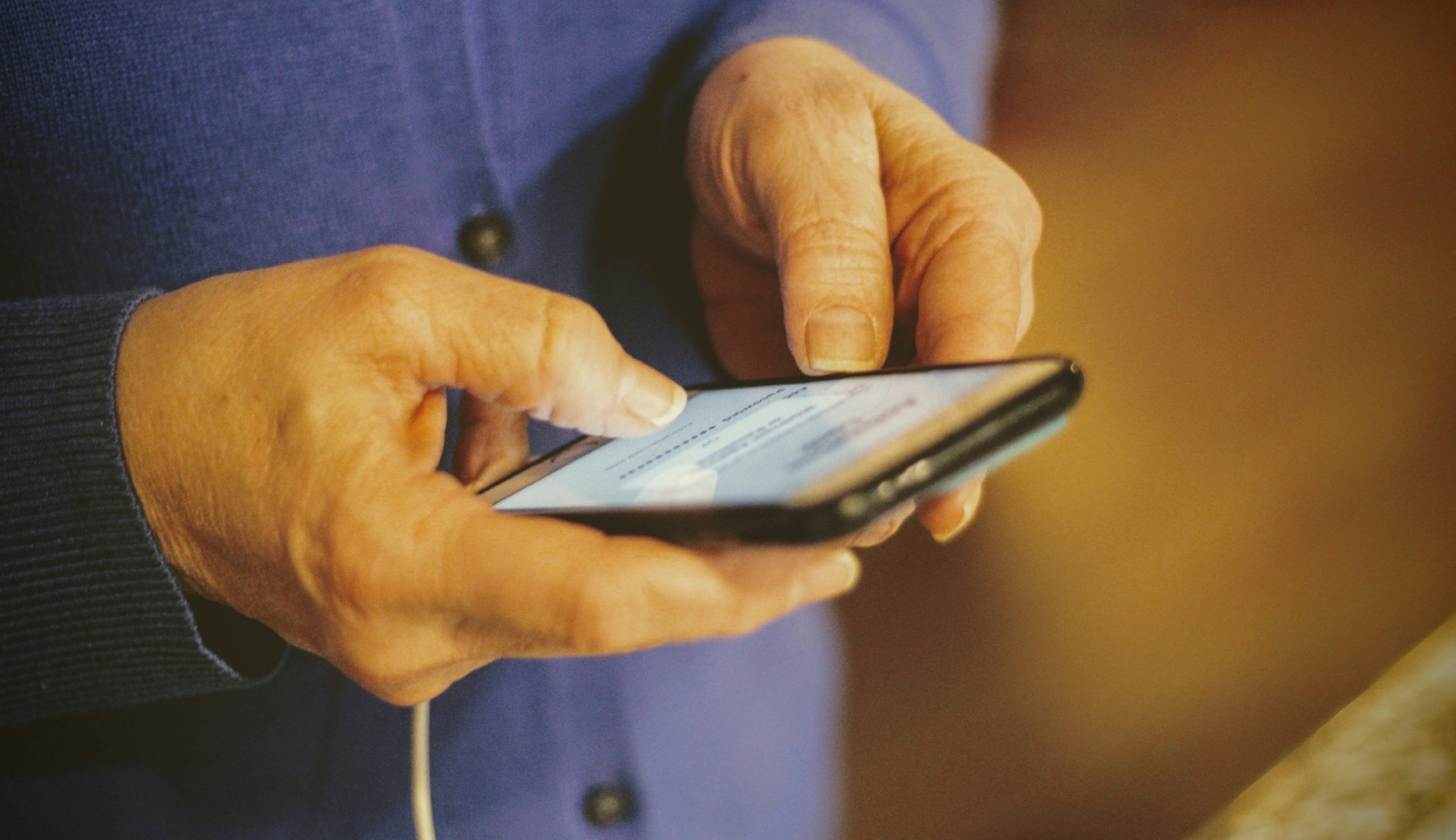 Un'anziana tiene un telefono in mano