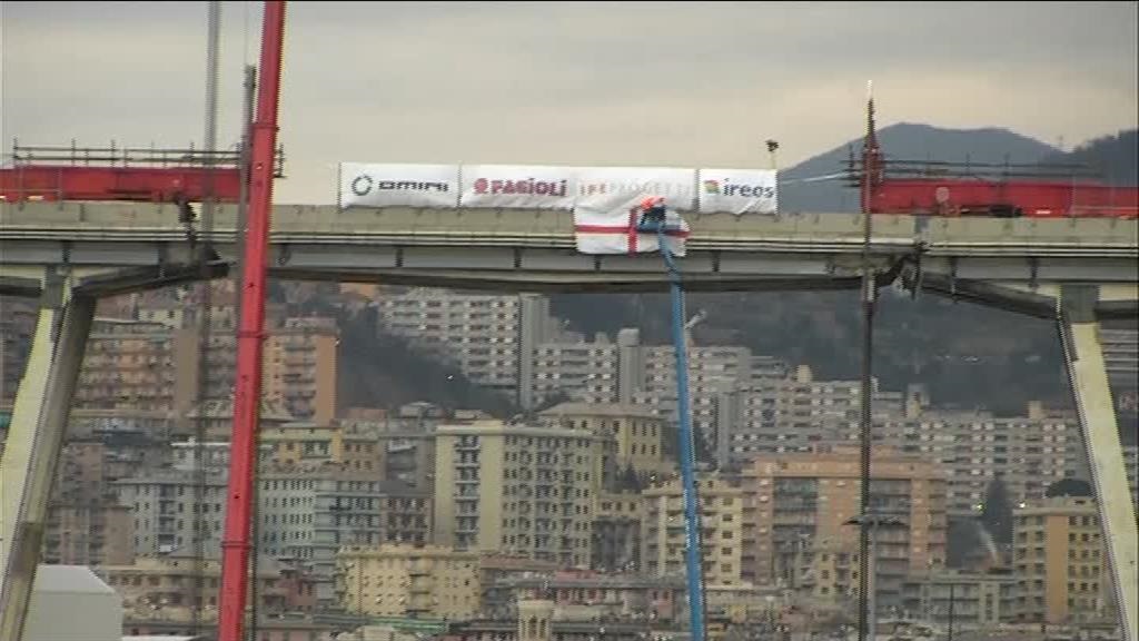 Sul pezzo di ponte Morandi da portare giù posizionata la bandiera di Genova